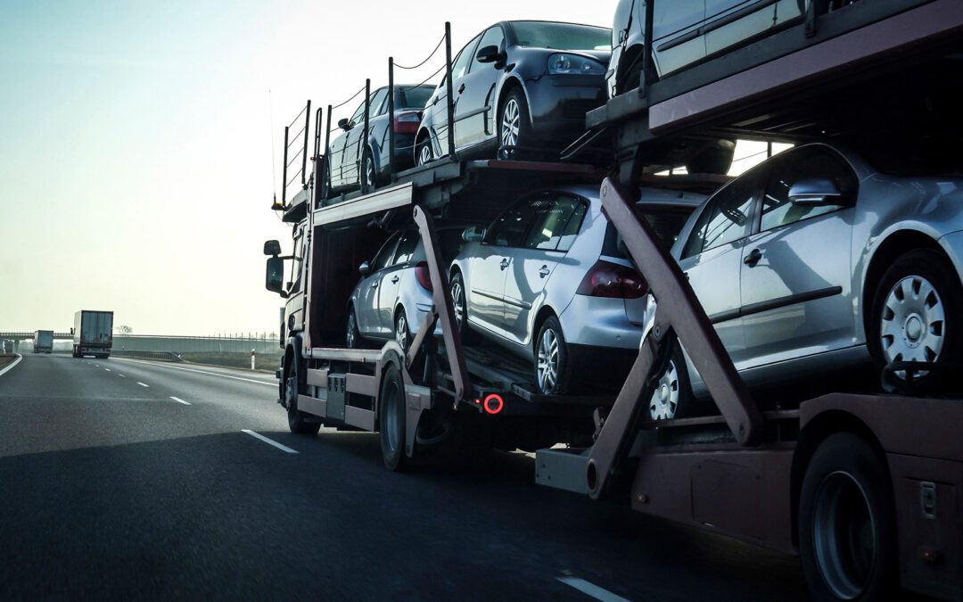 Car transporter trailer loaded with many cars on a highway, motion blur effect.
